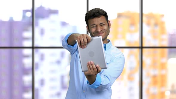 Very Emotional Darkskinned Man Plays Game on This Tablet Pc alt