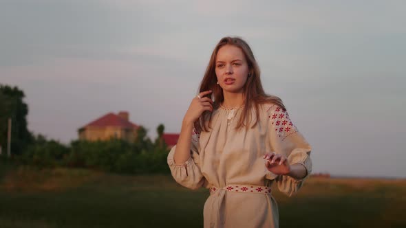 Happy Young Woman Enjoying the Sunset Wearing Traditional Ukrainian Clothes alt