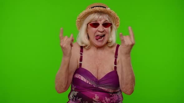 Senior Woman Tourist in Swimsuit Dancing Celebrating Showing Tongue Rock and Roll Hand Gesture alt