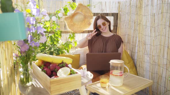 Woman in Brown Blouse and Sunglasses Has Videocall on Laptop
