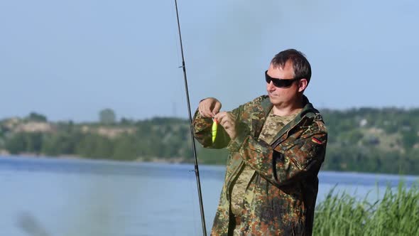 Man Clings a Bait To a Fishing Rod, He Wants To Catch Fish alt