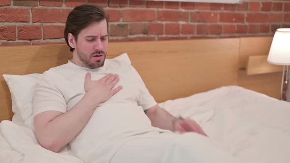 Casual Young Man Crying While Sitting in Bed alt