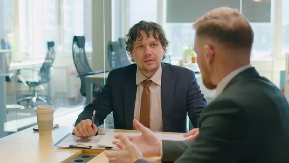 Business Partners Speaking and Shaking Hands in Office alt
