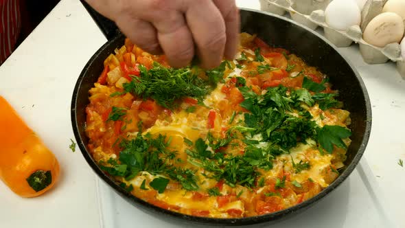 Chef Sprinkles with Herbs Fried Eggs Shakshuka in Vegetables Sauce Who Preparing on Frying Pan alt