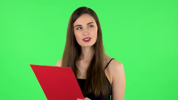 Woman Fills Papers in Red Folder with Pen. Green Screen alt