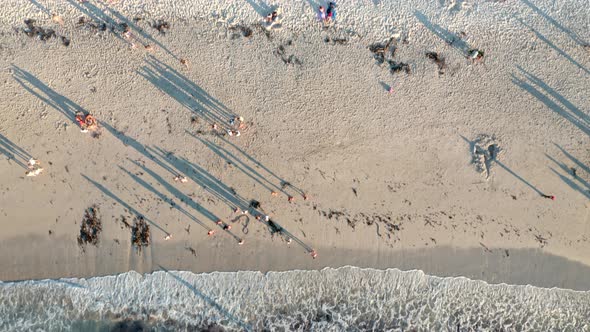 Top down view of people enjoying their time at the beach during sunset