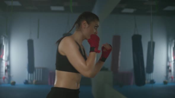Woman Fighter Trains His Punches and Defense in the Boxing Gym a Boxer Trains in Front of a Mirror alt