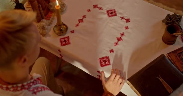 Beautiful Embroidered Tablecloth Lies on the Table a Man Opens an Old Book About Slavic Script alt