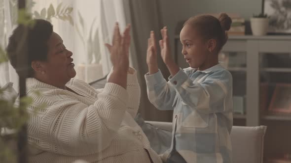 Senior Woman and Girl Playing Pat-a-cake alt