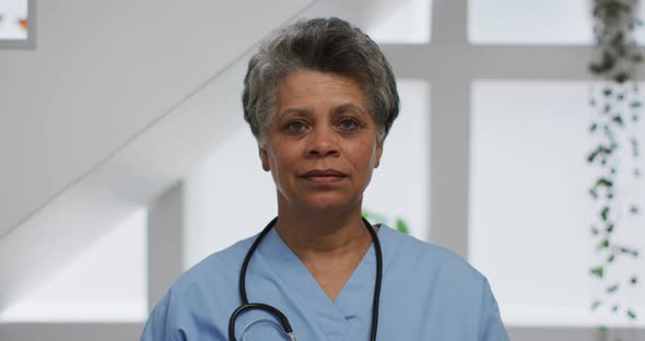 Portrait of senior african american female doctor looking at camera and smiling alt