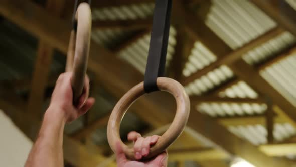 Side view of a shirtless athletic Caucasian man training at a gym alt