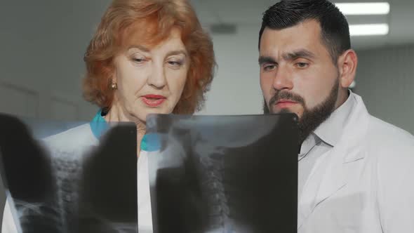 Two Doctors Discussing X-ray Scans of Their Patient