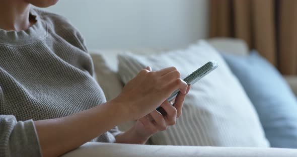 Woman use of mobile phone at home alt