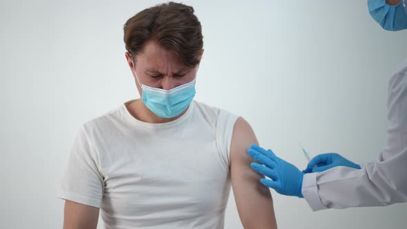 Caucasian Male Patient Feeling Pain in Arm After Coronavirus Vaccination in Medical Clinic alt