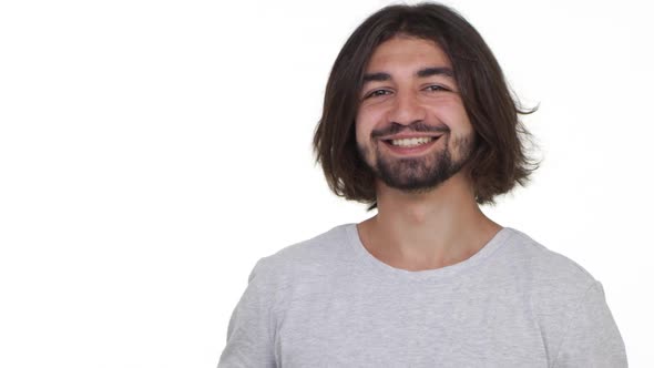 Happy Cool Guy Smiling and Pointing at Camera Isolated Over White Background in Slowmotion alt