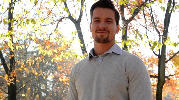Handsome Young Satisfied Guy Stands in the Forest Who Has Sunshine Behind His Head alt
