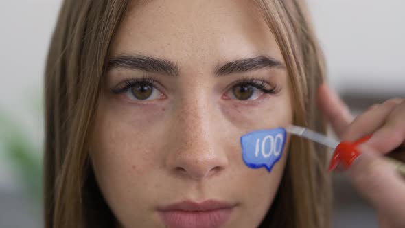 Close-up Portrait of Young Pleasant Woman Looking at Camera While Artist Painting Message Box alt