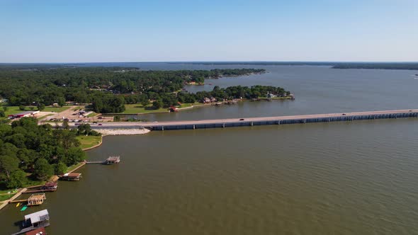 Aerial footage of Cedar Creek Lake in Texas.  Drone approaches Cedar Creek Parkway. alt