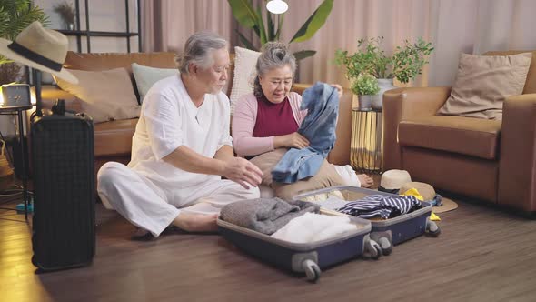 happiness asian old age retired mature adult enjoy arrange cloth together on floor