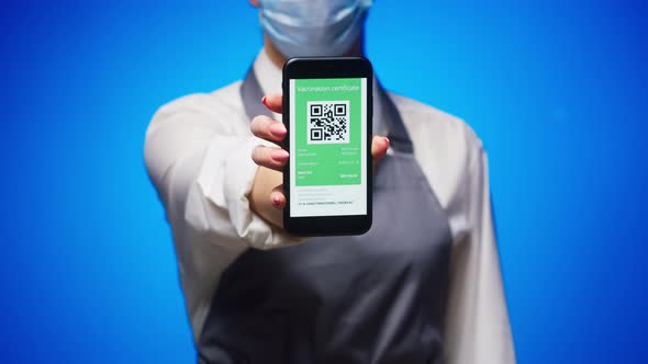 Woman Worker Showing on Phone Vaccination Passport with Qr Code on Blue Background International alt