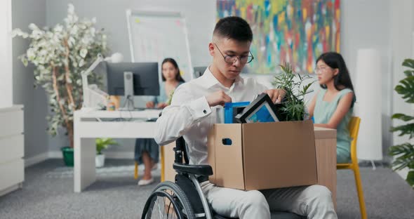 Young Corporate Office Worker Injured Accident Disabled in Wheelchair Holding a Box of Paraphernalia alt