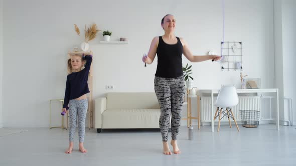 Woman with Daughter Doing Sport Exercises Indoors alt