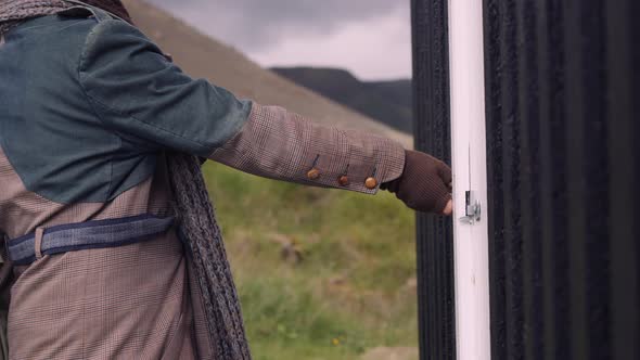 Closeup of a Stylish Man with a Scarf On Gets In the Little Black House alt