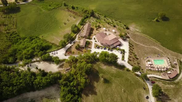 Panning shot by drone of a pretty house with a pool, italian countryside alt