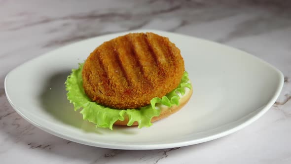 Fish Cutlet Falls on a Burger Bun With Lettuce