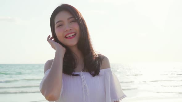 Beautiful female happy relax walking on beach near sea when sunset in evening. alt