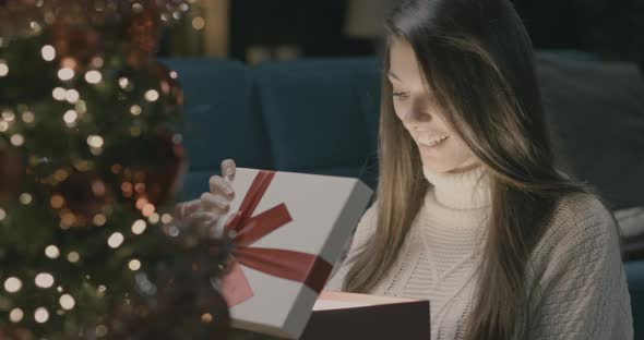 Young woman opening a christmas box.