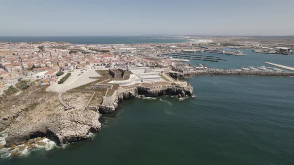Strategically placed Peniche Fortress on jagged cliff facing Atlantic; drone