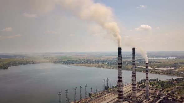 Aerial view of high chimney pipes with grey smoke from coal power plant. Production of electricity  alt