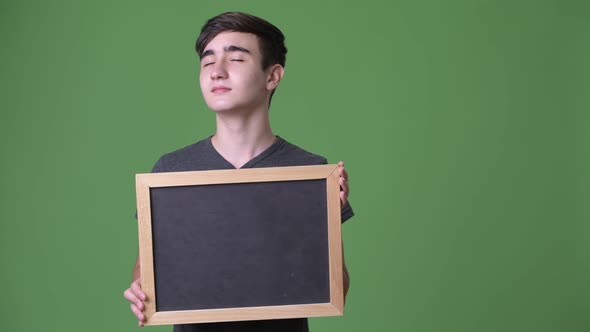 Young Handsome Iranian Teenage Boy Against Green Background alt