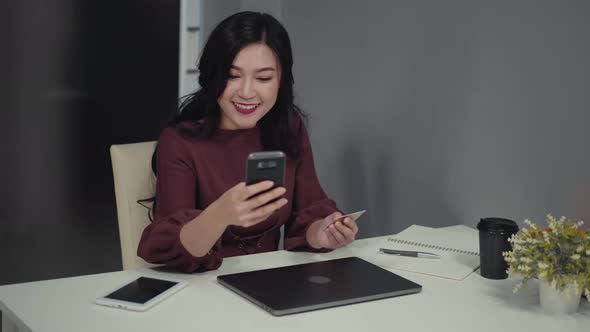 happy woman using smartphone for online shopping with credit card