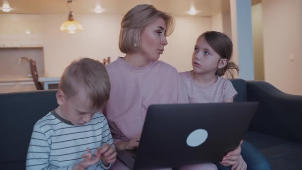 Woman with Son and Daughter Using Laptop at Home