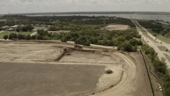 A dump truck travels on the construction site within a lake side town. alt