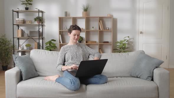 Relaxed Young Woman Resting on Couch Put Laptop on Laps Start Video Conference Greeting Family Wave alt