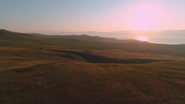 Aerial Field of Dry Yellow Grass. Steppe on Olkhon Island. Lake Baikal, Russia. Drone Footage Hills alt