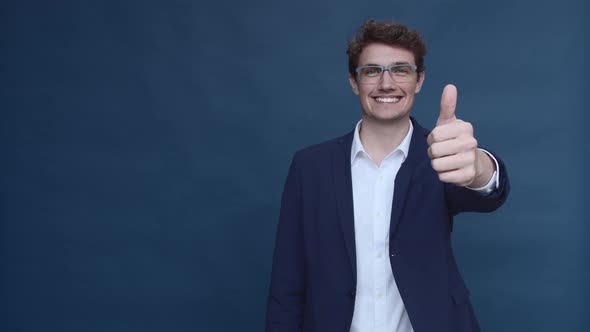 Male Model in Business Suit and Glasses Giving a Thumbs Up alt