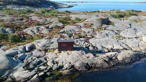 Aerial Drone Shot of A Cabin at A Rocky Ocean Coastline