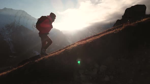 Aerial View of Epic Shot of a Girl Walking on the Edge of the Mountain As a Silhouette alt