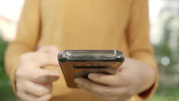 Asian tourist blogger woman using touchscreen technology at smartphone while walking.