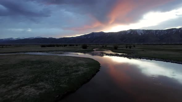 Drone flying backwards as sun is lighting up clouds alt
