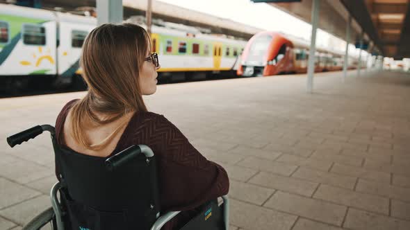 Lonely Young Caucasian Woman in the Wheelchair on the Train Station alt
