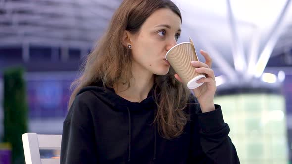 A Girl Holding a Cup of Coffee in Hand alt