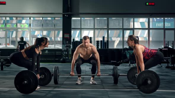 Man and woman athletes do deadlift with barbell, bodybuilders train, gym alt