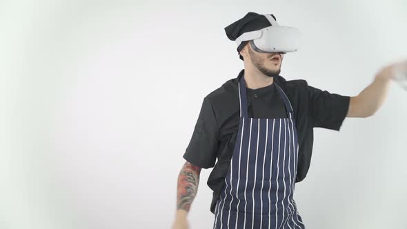 Chef Wearing Virtual Reality Headset Playing Game with Swords, Slashing Around Using Controllers alt