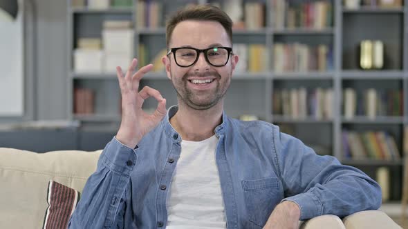 Portrait of Cheerful Young Man Doing OK Sign in Loft Office  alt