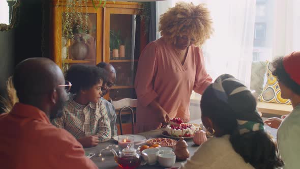 Woman Serving Sweet Cake for Family at Home Dinner alt